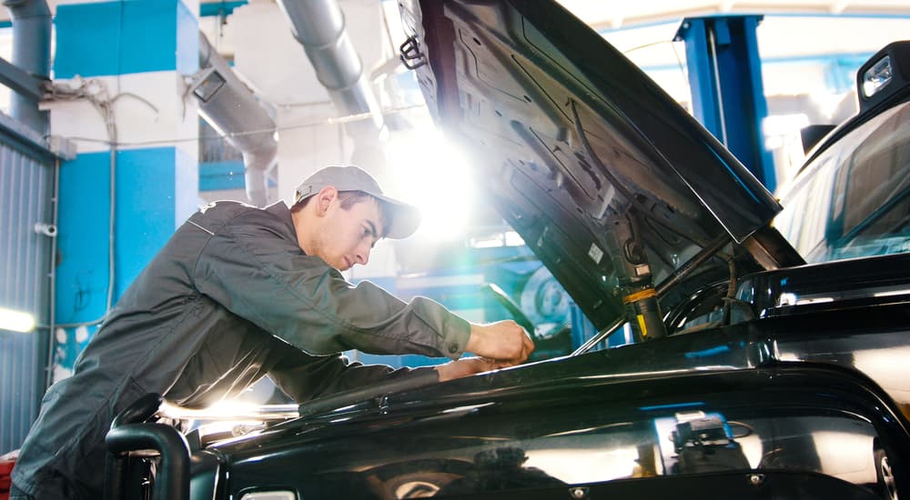 A mechanic working under the hood of a vehicle.