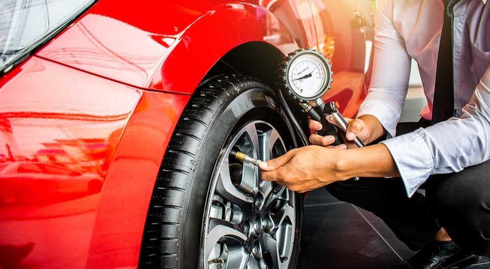 A person checking tire pressure.