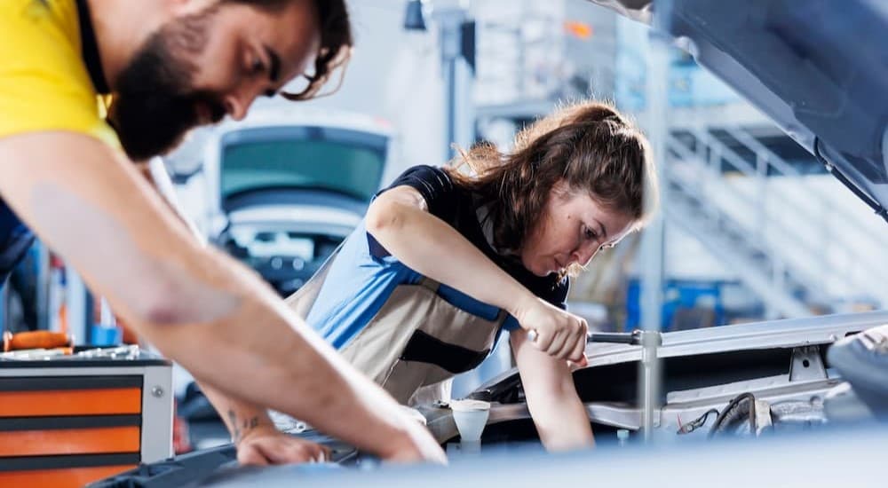 Two technicians working on an engine.