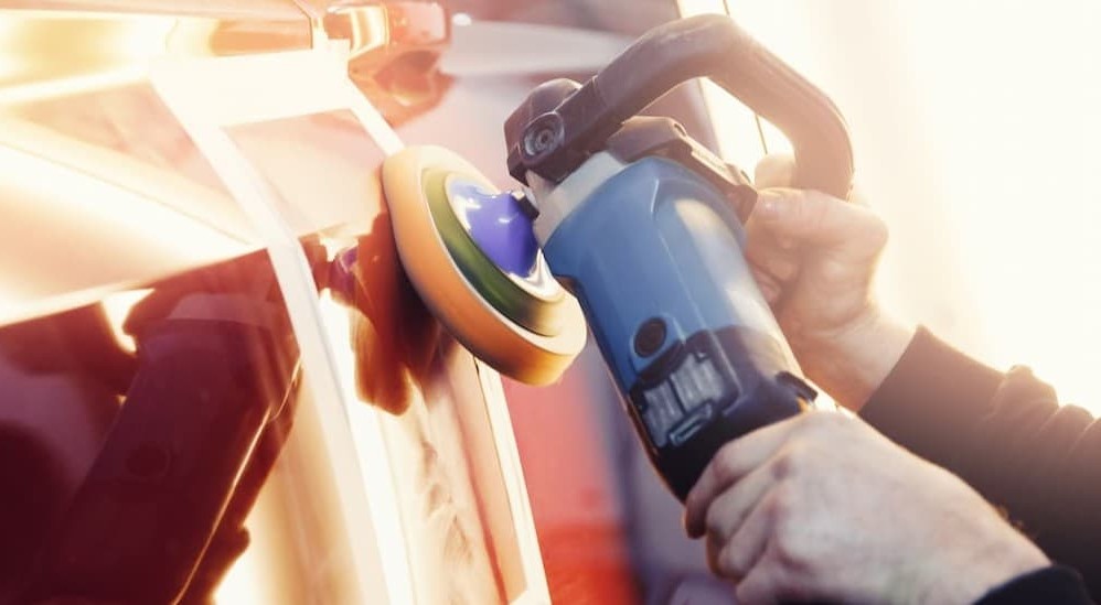 A person buffing a vehicle.