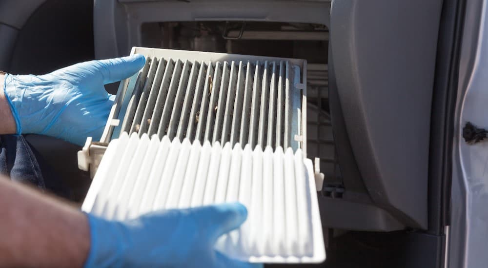 A person holding two cabin air filters.