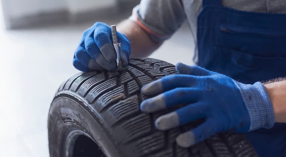 A technician measuring tire tread depth.